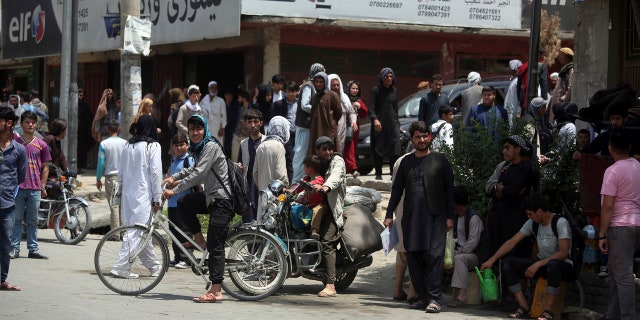 Afghan bystanders watch the aftermath of a deadly suicide attack in Kabul, Afghanistan, Monday, June 4, 2018.