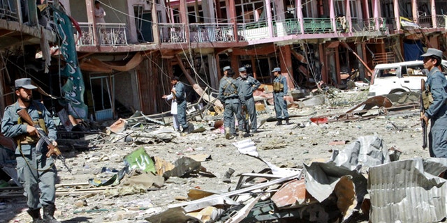 Sept. 4, 2014: Afghan security forces walk at the site of a suicide attack in Ghazni, Afghanistan. The Taliban struck a government compound in eastern Afghanistan early on Thursday in an attack that included two suicide truck bombings and left nearly a dozen dead, including several off duty policemen asleep in their quarters nearby, officials said.