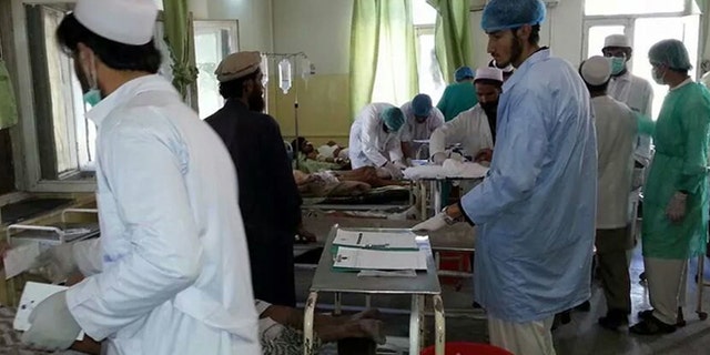 July 15, 2014: Afghan doctors assist civilians who were wounded when a suicide bomber detonated his explosives-packed vehicle near a crowded market and a mosque, in the main hospital in Sharan, capital of Paktika province, Afghanistan.