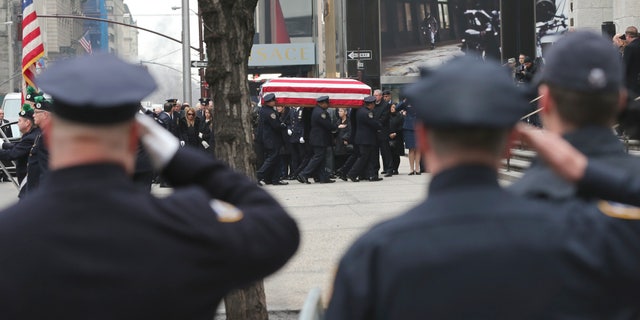 Police officers salute Joseph Lemm as his casket passes before them.