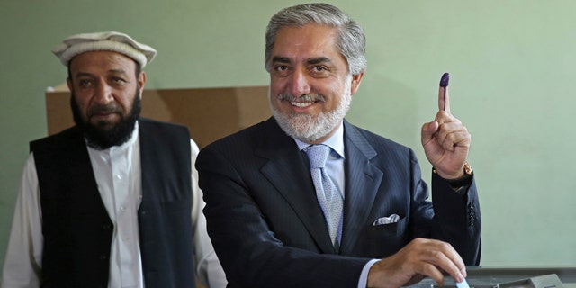June 14, 2014: Afghanistan's presidential candidate Abdullah Abdullah, right, poses for photos before he casts his vote as his first vice president candidate, Mahoammad Khan, left, waits at a pooling station in Kabul, Afghanistan.