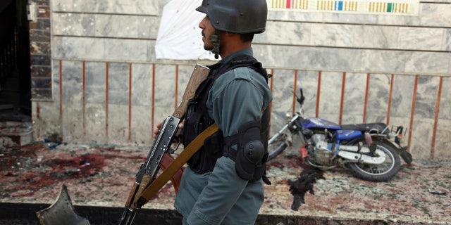 An Afghan police walks outside a voter registration center which was attacked by a suicide bomber in Kabul, Afghanistan, Sunday, April 22, 2018.
