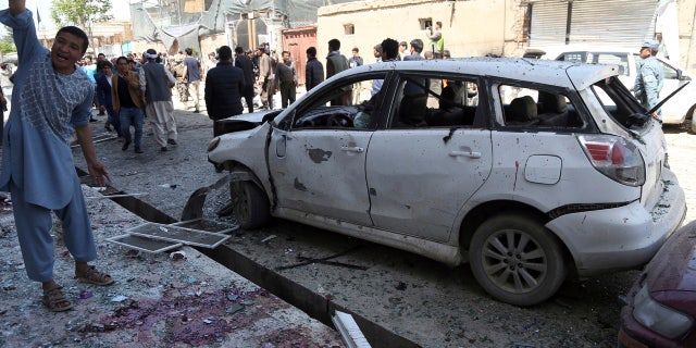 People gather outside a voter registration center which was attacked by a suicide bomber in Kabul, Afghanistan, Sunday, April 22, 2018.