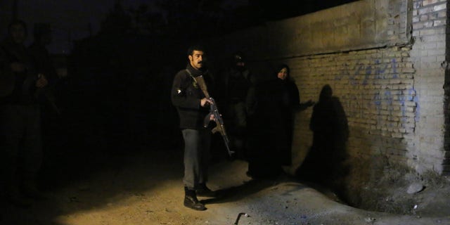 An Afghan policeman stands at the site of an explosion in Kabul.