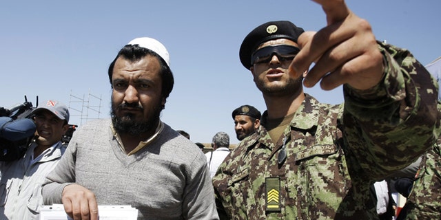 Sept. 10, 2012: An Afghan soldier, right, escorts a released prisoner, Mohammad Karim, following a hand over ceremony of U.S.- run prison to Afghan government in Bagram north of Kabul, Afghanistan.