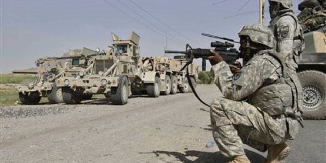 Thursday: A U.S. soldier looks at an approaching man through the sights of his assault rifle as the soldiers provide security during investigations at a site of suicide attack in Kandahar, Afghanistan. (AP Photo)