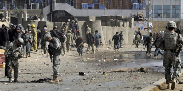 Dec. 27: U.S soldiers and Afghan policemen are seen at the scene of a suicide attack in Kandahar south of Kabul, Afghanistan. On Dec. 28 a U.S. military commander says it's 'naive' to think there's a practical way to seal Afghanistan's vast border with Pakistan and stop all Taliban fighters from slipping through.