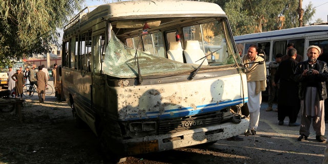 People look at a damaged bus after a suicide attack in Jalalabad city, Afghanistan November 23, 2017