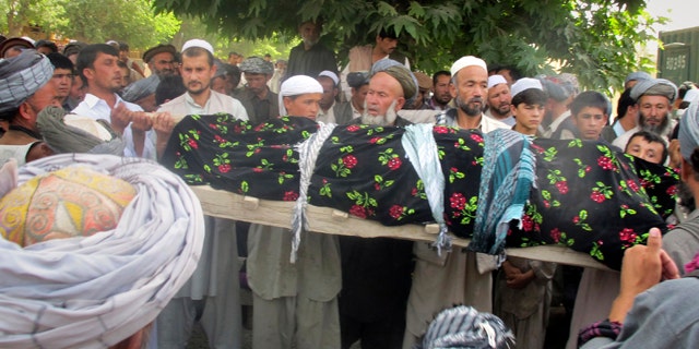 May 18: Afghani people hold the lifeless body of one of the four Afghans, killed during a NATO raid in Taloqan, Takhar province, north of Kabul, Afghanistan on Wednesday. More than 1,000 protesters poured into a northern Afghan city Wednesday, shouting "Death to America!" and calling for justice as they clashed with security forces following an overnight NATO raid they claim killed four civilians. (AP)