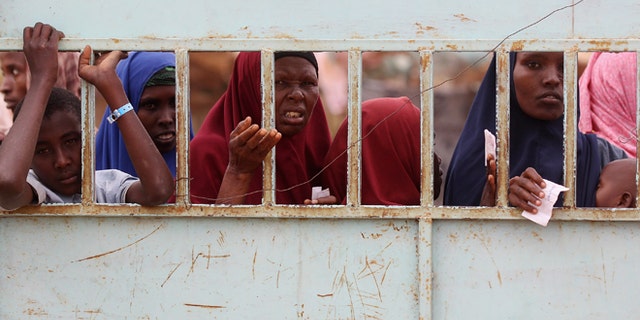DADAAB, KENYA - JULY 23: Somalian refugees wait at the entrance to the registration area of the IFO refugee camp which makes up part of the giant Dadaab refugee settlement on July 23, 2011 in Dadaab, Kenya. The refugee camp at Dadaab, located close to the Kenyan border with Somalia, was originally designed in the early 1990s to accommodate 90,000 people but the UN estimates over 4 times as many reside there. The ongoing civil war in Somalia and the worst drought to affect the Horn of Africa in six decades has resulted in an estimated 12 million people whose lives are threatened. (Photo by Oli Scarff/Getty Images)