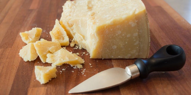 pieces of parmesan cheese on a wooden cutting board