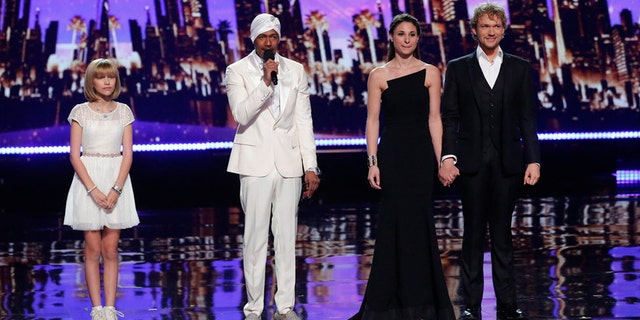 Grace VanderWaal (left) and The Clairvoyants (right) wait to hear host Nick Cannon (center) announce the "America's Got Talent" winner.