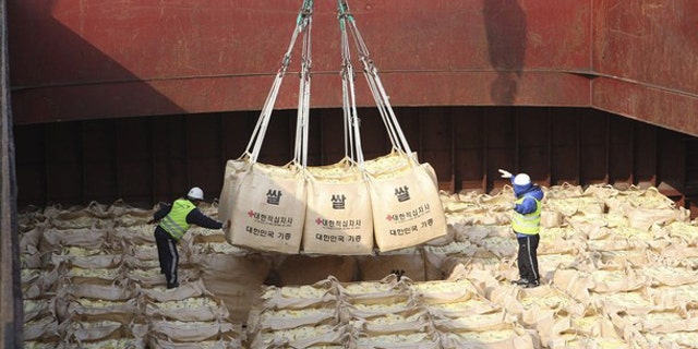 Workers load packs of rice as food aid for flood-stricken North Koreans onto a ship at a port in Gunsan, about 168 miles south of Seoul, Oct. 22, 2010.