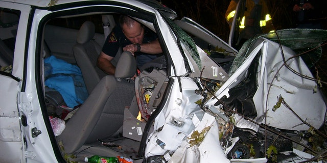 In this Oct. 24, 2006 photo provided by the St. Croix County Sheriff's Office, police investigate the wreckage of a 2005 Chevrolet Cobalt that crashed in St. Croix County, killing Natasha Weigel, 18, and Amy Lynn Rademaker, 15, and injuring the 17-year-old driver, Megan Ungar-Kerns. The vehicle's ignition was found in the accessory position and the air bags didnt deploy. General Motors recent recall of 2.6 million small cars, including the 2005 Cobalt, has shed light on an unsettling fact: Air bags might not always deploy when drivers _ and federal regulators _ expect them to. (AP Photo/St. Croix County Sheriff's Office)