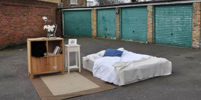 An airy "room" with a bed, cabinet nightstand... and plenty of space to walk around.