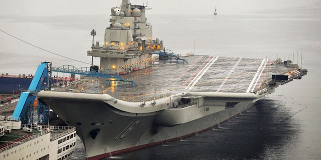 FILE 2012: China's first aircraft carrier, which was renovated from an old aircraft carrier that China bought from Ukraine in 1998, is seen docked at Dalian Port.