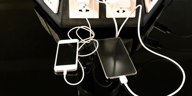 Charging station for mobile smart phones at international airport - Helpful corner for electronical modern technology devices and smartphones