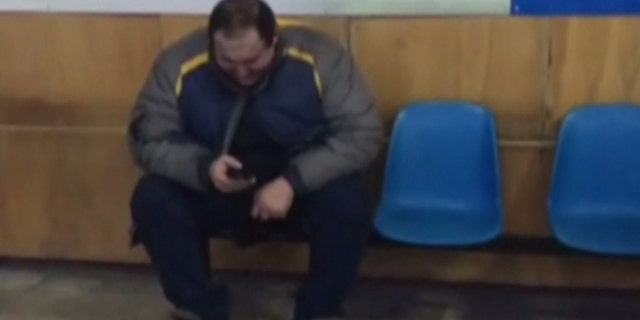 A man reacts in an airport in Orsk, Russia after a plane with 71 people on board crashed shortly after takeoff from Moscow.