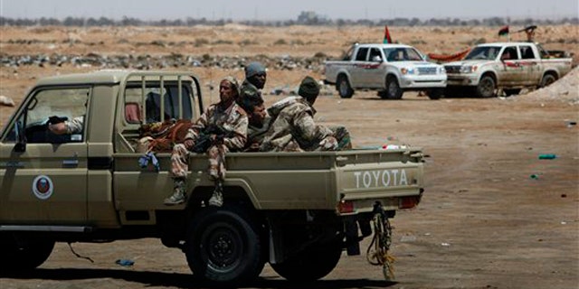 Libyan rebel fighters patrol along the western gate of Ajdabiya, Libya, April 23.
