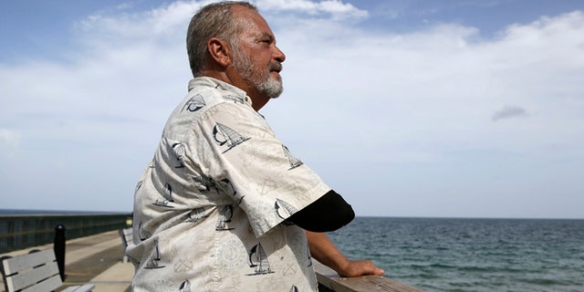 Aug. 5, 2015: Al Brennaka, 57, poses for a photograph in Pompano Beach, Fla. Brennaka lost half his arm at age 19 after being attacked by a shark while surfing off Daytona Beach.