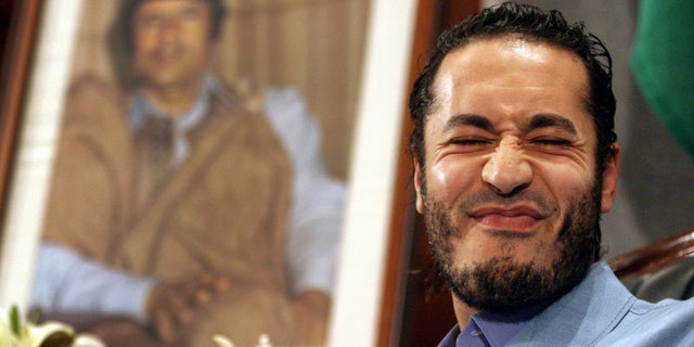 In this file photo of Monday, Feb. 7, 2005 Al-Saadi Gadhafi, the son of Libyan leader Moammar Gadhafi, reacts in front of the leader's portrait during a press conference in Sydney, Australia. The spokesman for Niger's government announced Sunday that Libyan leader Muammar Qaddafi's son Al-Saadi has entered the country via the northern desert separating the landlocked African nation from Libya.