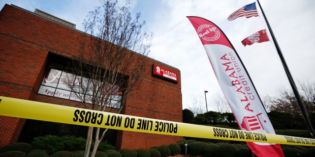 Police tape surrounds the Alabama Credit Union building after reports of a hostage standoff, Tuesday, Jan. 10, 2017, in Tuscaloosa, Ala. A group of hostages was freed, unharmed, and a man with a gun was arrested Tuesday at the credit union branch near the University of Alabama, police said. (AP Photo/Brynn Anderson)