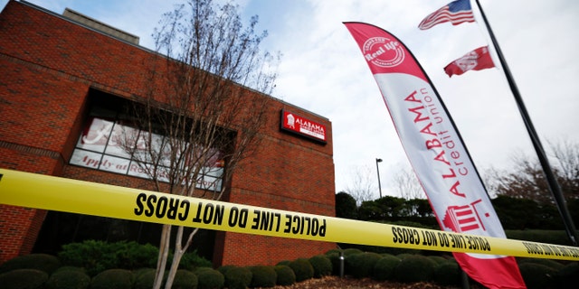 Police tape surrounds the Alabama Credit Union building after reports of a hostage standoff, Tuesday, Jan. 10, 2017, in Tuscaloosa, Ala. A group of hostages was freed, unharmed, and a man with a gun was arrested Tuesday at the credit union branch near the University of Alabama, police said. (AP Photo/Brynn Anderson)