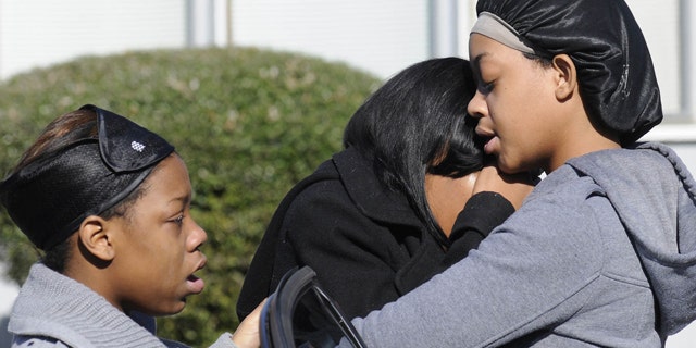 Jan. 29, 2012: Ravenn Carlton, center, wife of one of the five people found dead is comforted by Nakia Carlton, left, and Khalena Carlton, right, near the scene where five people were found dead inside a house in Birmingham, Ala.
