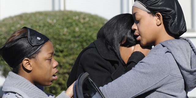 Jan. 29, 2012: Ravenn Carlton, center, wife of one of the five people found dead is comforted by Nakia Carlton, left, and Khalena Carlton, right, near the scene where five people were found dead inside a house in Birmingham, Ala.