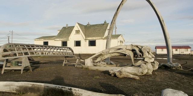 ILE - In this Aug. 12, 2005, file photo. a skin boat display sits next to whale bones and an arch made of a whale jaw on the beach at Brower's Cafe in Barrow, Alaska.