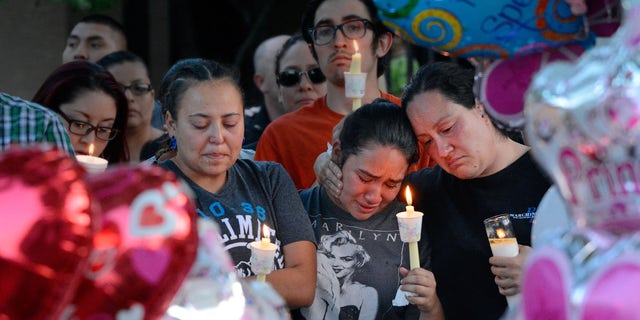 Aug. 25, 2016: Nicole Maldonado, Myriah Flores, and her mother Sharlene Benavidez attend a candlelight vigil for 10-year-old Victoria Martens at the apartment complex, in Albuquerque, N.M., where the young girl lived and was killed.