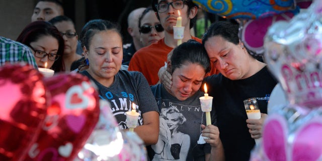 Aug. 25, 2016: Nicole Maldonado, Myriah Flores, and her mother Sharlene Benavidez attend a candlelight vigil for 10-year-old Victoria Martens at the apartment complex, in Albuquerque, N.M., where the young girl lived and was killed.