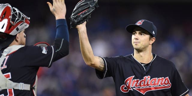 Cleveland Indians starting pitcher Ryan Merritt, right, celebrates with catcher Roberto Perez after an inning-ending double play against the Toronto Blue Jays during the fourth inning in Game 5 of baseball's American League Championship Series in Toronto, Wednesday, Oct. 19, 2016. (Frank Gunn/The Canadian Press via AP)