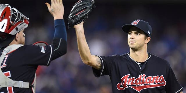 Cleveland Indians starting pitcher Ryan Merritt, right, celebrates with catcher Roberto Perez after an inning-ending double play against the Toronto Blue Jays during the fourth inning in Game 5 of baseball's American League Championship Series in Toronto, Wednesday, Oct. 19, 2016. (Frank Gunn/The Canadian Press via AP)