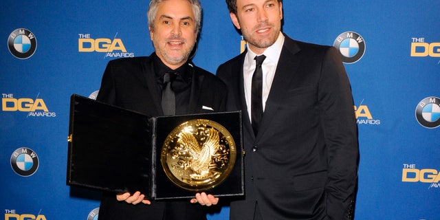 January 25, 2014. Actor and director Ben Affleck (R) presents Mexican director Alfonso Cuaron with the Feature Film award for "Gravity"during the 66th annual Directors Guild of America Awards in Beverly Hills, California.