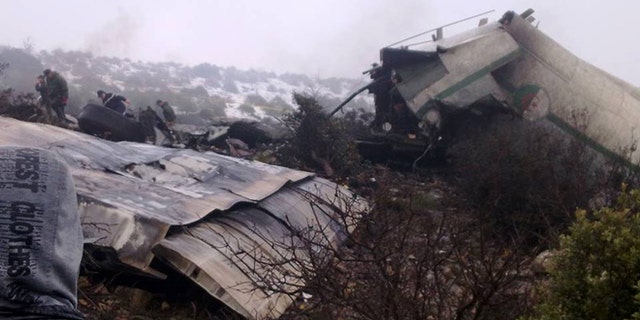 Feb. 11, 2014: A man watches rescue workers working at the wreckage of Algerian military transport aircraft after it slammed into a mountain in the country's rugged eastern region.