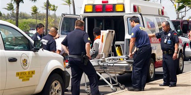 A 16-year-old boy, seen sitting on a stretcher center, who stowed away in the wheel well of a flight from San Jose, Calif., to Maui is loaded into an ambulance at Kahului Airport in Kahului, Maui, Hawaii Sunday afternoon, April 20, 2014. The boy survived the trip halfway across the Pacific Ocean unharmed despite frigid temperatures at 38,000 feet and a lack of oxygen, FBI and airline officials said. FBI spokesman Tom Simon in Honolulu told The Associated Press on Sunday night that the boy was questioned by the FBI after being discovered on the tarmac at the Maui airport with no identification. "Kid's lucky to be alive," Simon said. (AP Photo/The Maui News, Chris Sugidono)