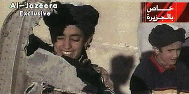 In this image made from video broadcast by the Qatari-based satellite television station Al-Jazeera Wednesday, Nov. 7, 2001, a young boy, left, identified as Hamza bin Laden holds what the Taliban says is a piece of U.S. helicopter wreckage in Ghazni, Afghanistan on Monday, Nov. 5, 2001. 