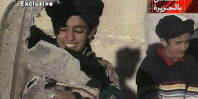 In this image made from video broadcast by the Qatari-based satellite television station Al-Jazeera Wednesday, Nov. 7, 2001, a young boy, left, identified as Hamza bin Laden holds what the Taliban says is a piece of U.S. helicopter wreckage in Ghazni, Afghanistan on Monday, Nov. 5, 2001.