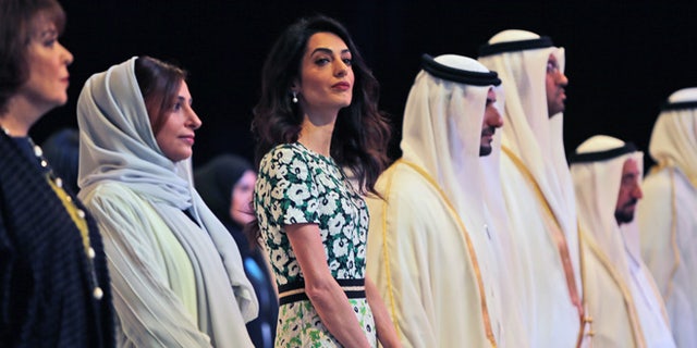 March 20, 2016. Amal Alamuddin Clooney, writer, human rights activist, 3rd left, listens to the national anthem during the opening ceremony of the International Government Communications Forum in Sharjah, United Arab Emirates.