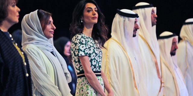 March 20, 2016. Amal Alamuddin Clooney, writer, human rights activist, 3rd left, listens to the national anthem during the opening ceremony of the International Government Communications Forum in Sharjah, United Arab Emirates.