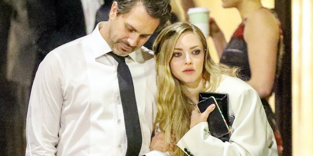 Amanda Seyfried cozies up to husband Thomas Sadoski at the 2018 Vanity Fair Oscar Party on March 5, 2018.