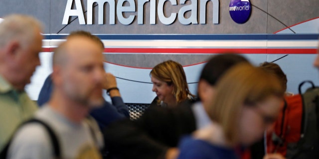 Travelers line up at an American Airlines ticket counter at O'Hare Airport in Chicago, Illinois, May 13, 2014.