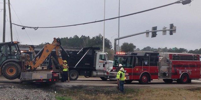 Authorities respond after an Amtrak train struck a trailer carrying construction equipment in Slidell, La.