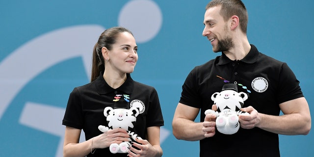 Bronze medalists Aleksandr Krushelnitskiy and Anastasia Bryzgalova, Olympic athletes from Russia, celebrate during the victory ceremony.