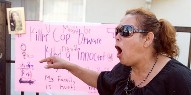 July 23, 2012: Maria, who wouldn't give her last name because she said she fears the police, shouts "no mas", at a memorial on Anna Drive in Anaheim, Calif. for Manuel Angel Diaz, 25, of Santa Ana.