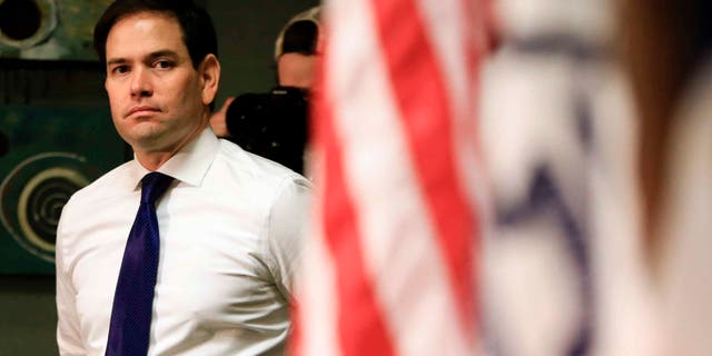 Sen. Marco Rubio waits at the side of the stage in Council Bluffs, Iowa, Sat. Jan. 16, 2016.