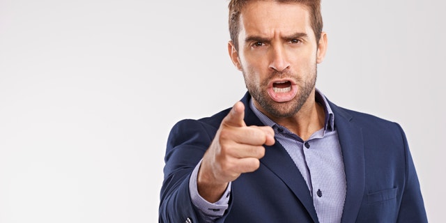 Portrait of an angry businessman pointing at the camera