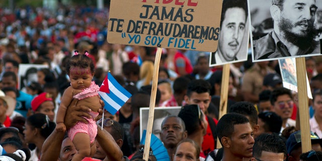 People wait at the beginning of a rally to honor Cuba's Fidel Castro in Santiago, Cuba, Dec. 3.