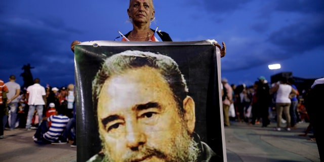 A woman holds a picture of Fidel Castro before a rally honoring Cuba's leader on Dec. 3 in Santiago, Cuba.